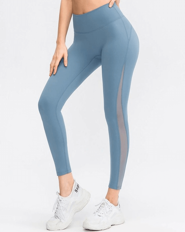Woman wearing blue seamless high-waist leggings, ideal for yoga, showing flexibility and comfort.